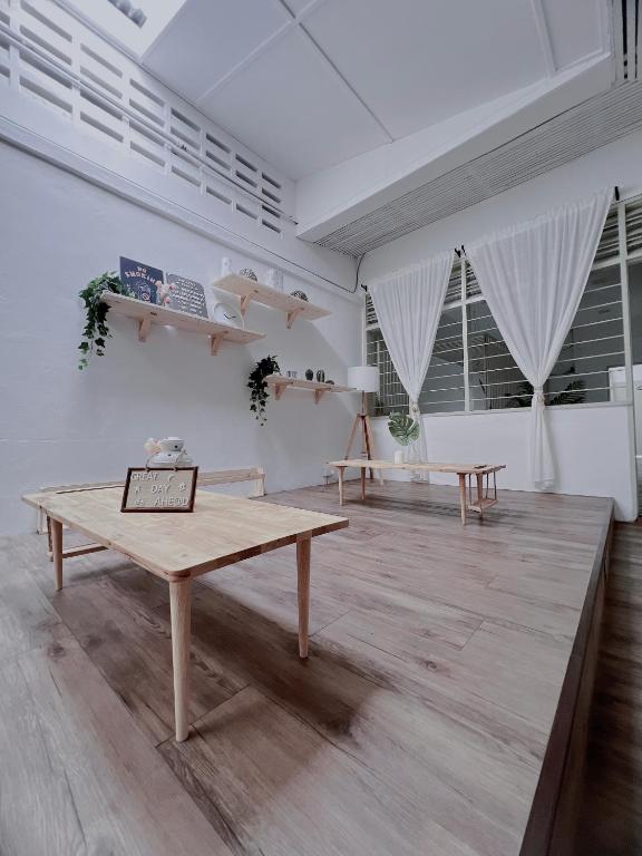 a living room with a table and two windows at The Cozy Place by Nestcove in Melaka