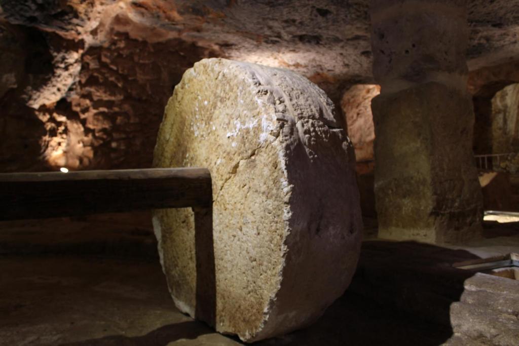 a large rock sitting in a room with a wall at Masseria Valente in Ostuni