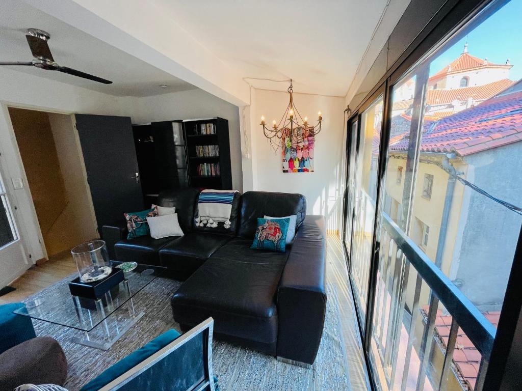 a living room with a couch and a balcony at Maison des Remparts in Céret