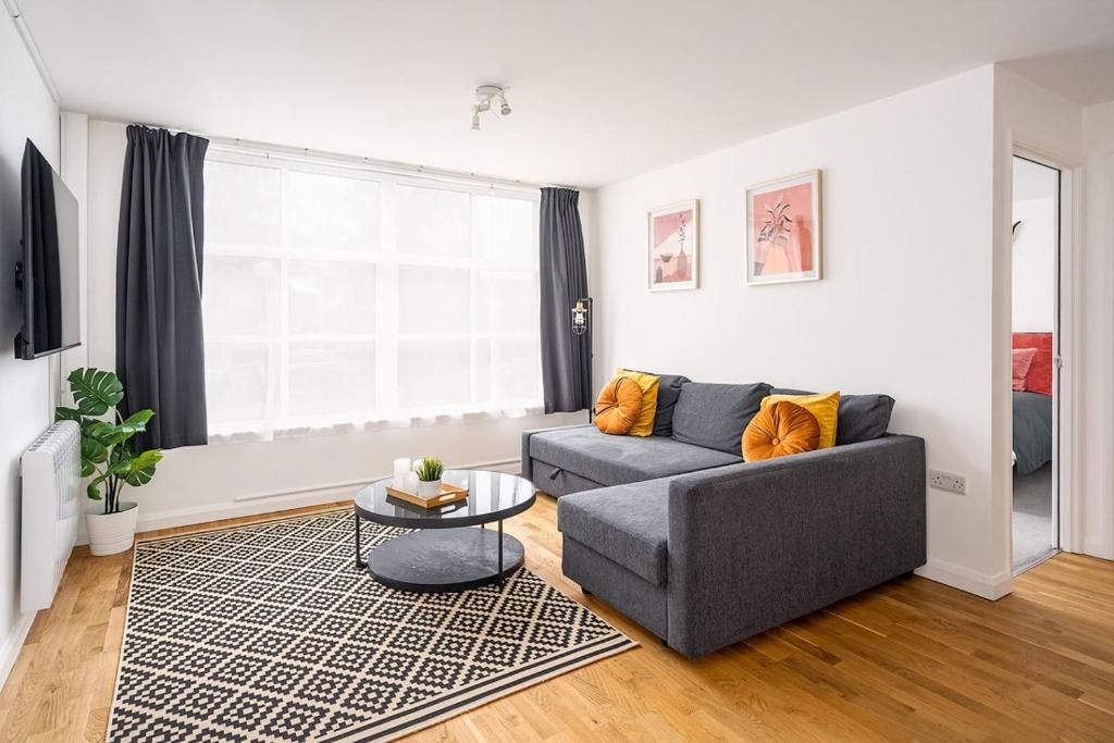 een woonkamer met een bank en een tafel bij Contemporary City Centre Apartment With Parking in Bath