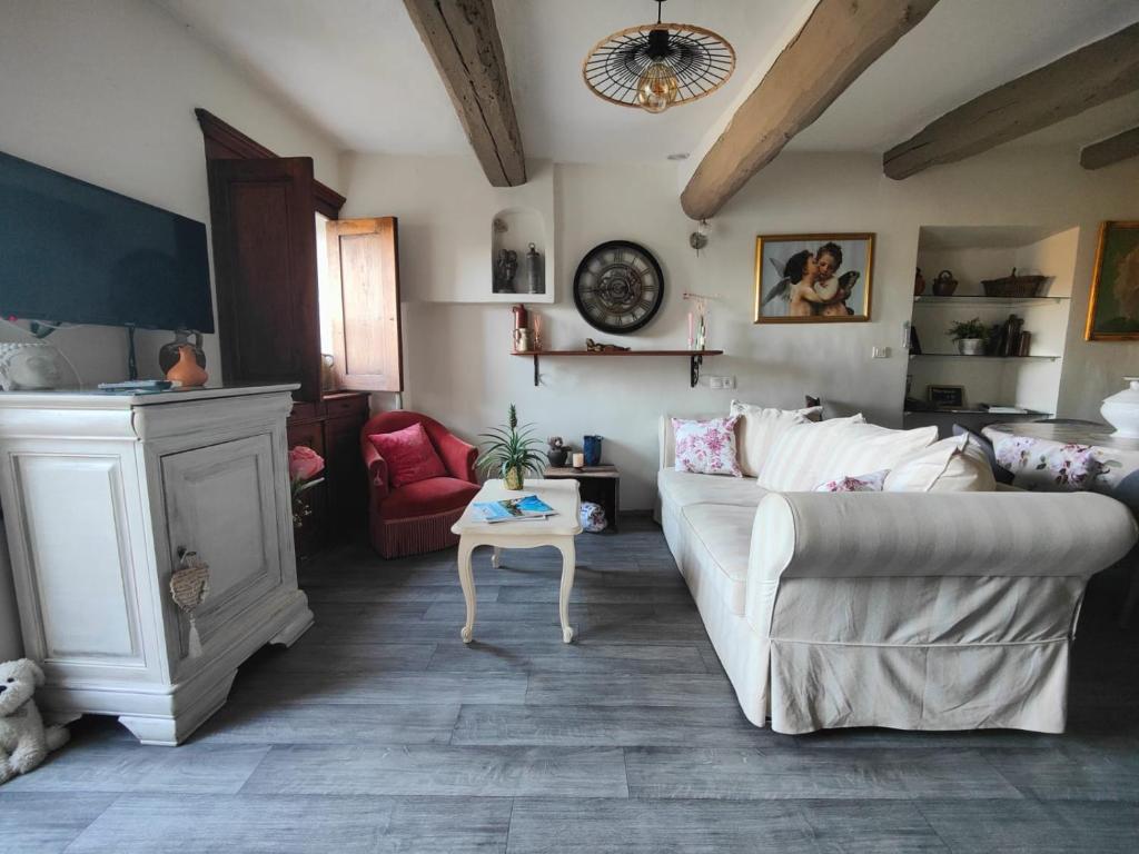 salon z białą kanapą i kominkiem w obiekcie Maison ancienne romantique avec terrasse panoramique w mieście Vaison-la-Romaine