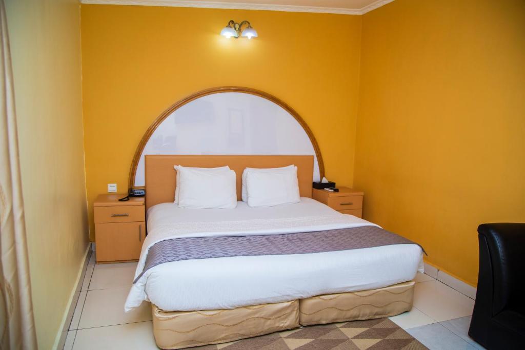 1 dormitorio con 1 cama grande y ventana abovedada en Airside Hotel en Accra