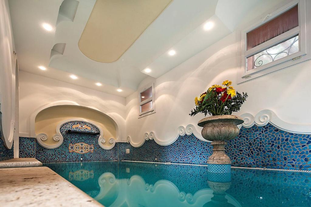 a swimming pool with a vase with flowers in it at Hotel Nettuno in Ischia