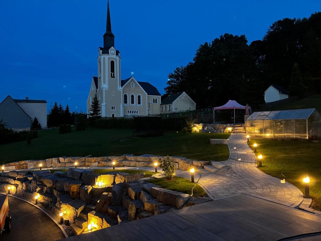 een grote witte kerk met 's nachts een toren bij Ferienwohnung Starennest in Thermalbad Wiesenbad