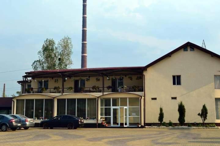 un gran edificio con coches estacionados en un estacionamiento en Cazare ANIMA en Baia Mare