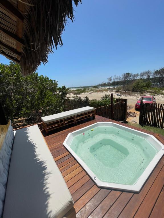 a hot tub on a wooden deck with the beach at Casa Mangue in Macapá