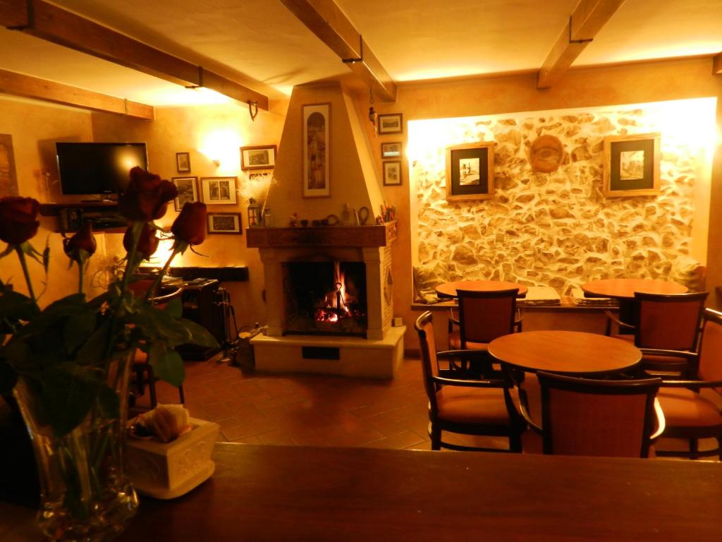 a living room with a fireplace and tables and chairs at Garnì B&B La Rua-Pescocostanzo in Pescocostanzo