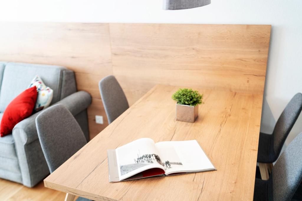 uma mesa com um livro e uma planta sobre ele em Berg Aparts Faschina Top 7 em Fontanella