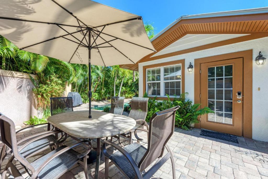 a table and chairs with an umbrella on a patio at Anna Maria Island Surfside Bungalow in Holmes Beach