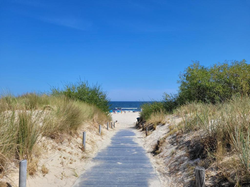 a wooden path leading to a sandy beach at Gemütliche Ferienwohnung - Araliya 1 in Ahlbeck