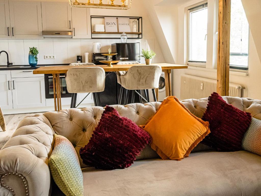 a living room with a couch with colorful pillows at Fabelhafte Apartments zum wohlfühlen mit JUNIK Apartments in Duisburg