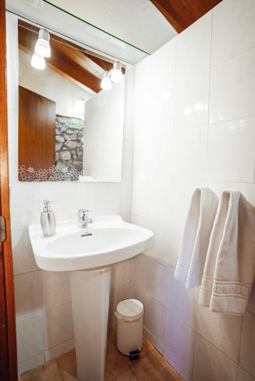 a white bathroom with a sink and a mirror at Casa Rural El Callís in Vall de Bianya