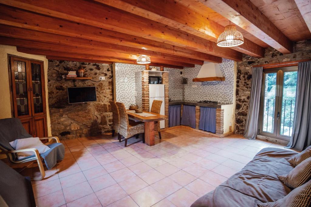 a living room with a table in a stone house at Casa Rural El Callís in Vall de Bianya