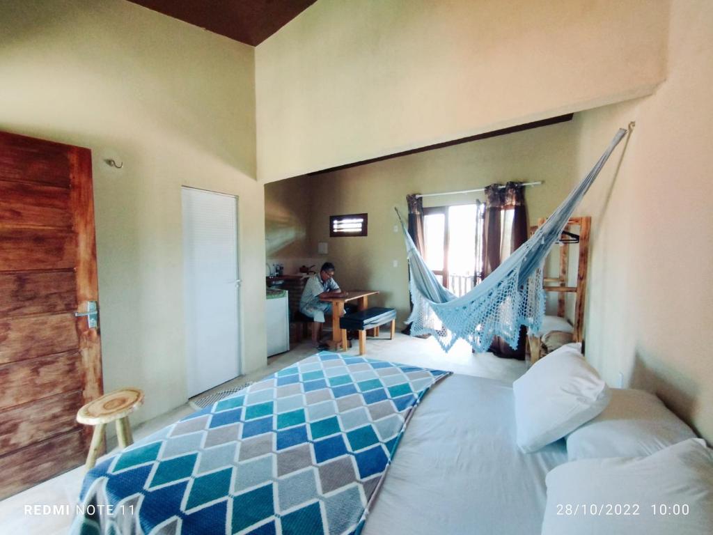 a bedroom with a bed with a hammock in it at Vila Samin Moitas in Praia de Moitas