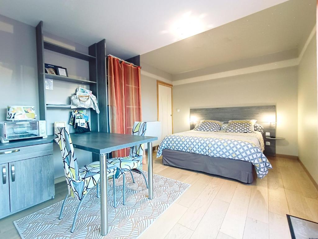 a bedroom with a bed and a table and chairs at Gîte des Douces'Eure in Cierrey