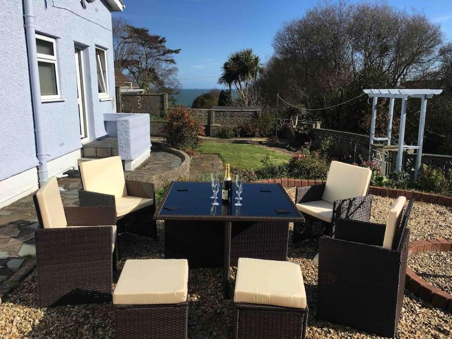 a patio with a table and chairs in a yard at Benllech Sea View bungalow, Dog Friendly sleeps 6 in Benllech