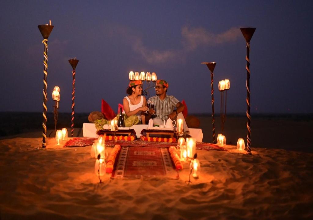 a man and a woman sitting on a beach at Sky Desert Safari in Sām