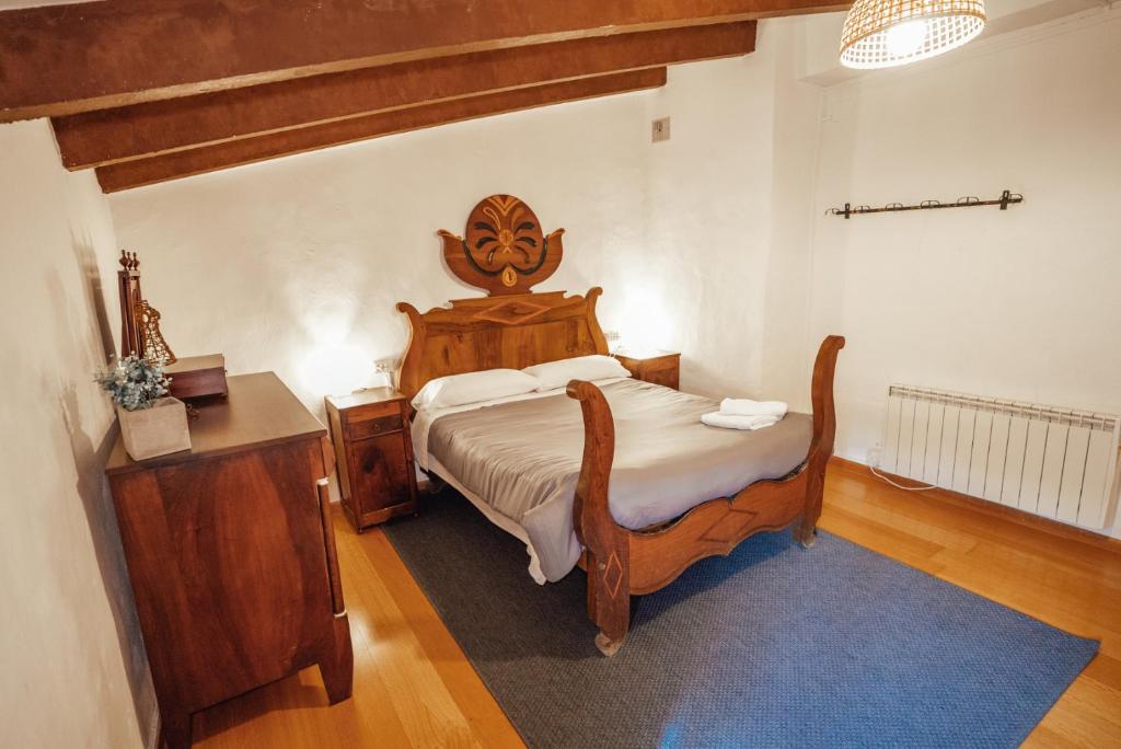 a bedroom with a wooden bed with a wooden headboard at Casa Rural El Callís in Vall de Bianya