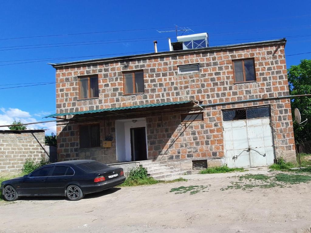 una macchina nera parcheggiata di fronte a una casa di mattoni di Garni Guesthouse a Garni