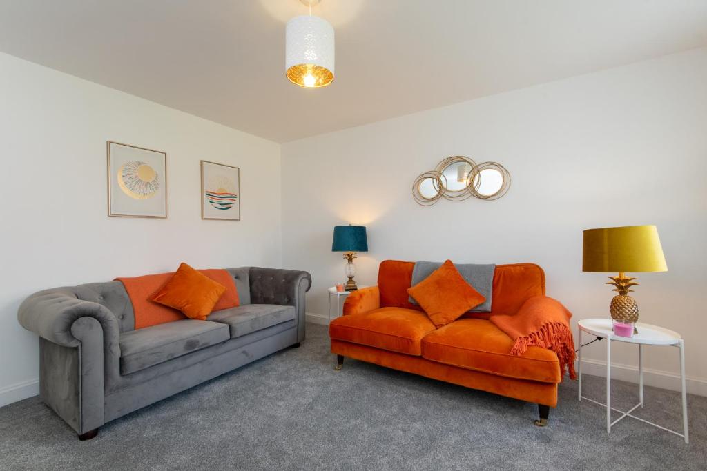 a living room with two couches and an orange chair at Bell Road in Durham