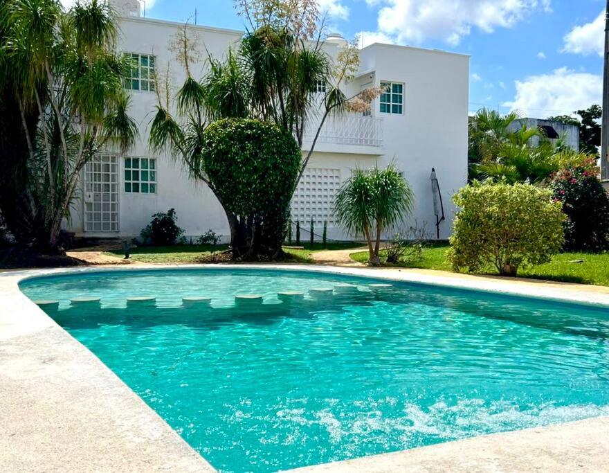 a swimming pool in front of a house at Casa Mar y Amor in Cancún