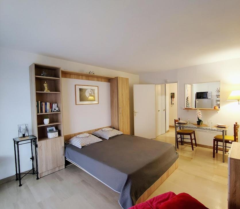 1 Schlafzimmer mit einem großen Bett und einer Küche in der Unterkunft Fréjus plage in Fréjus