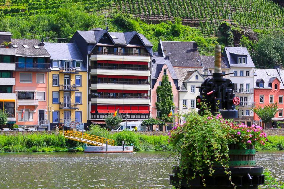 a group of houses next to a body of water at Weinhotel Mayer in Zell an der Mosel
