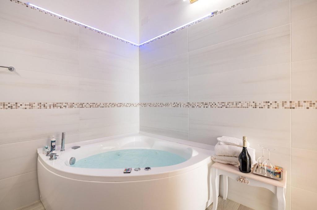 a white bathroom with a tub in it at Palazzo Giannotte Suite & Spa in Ostuni