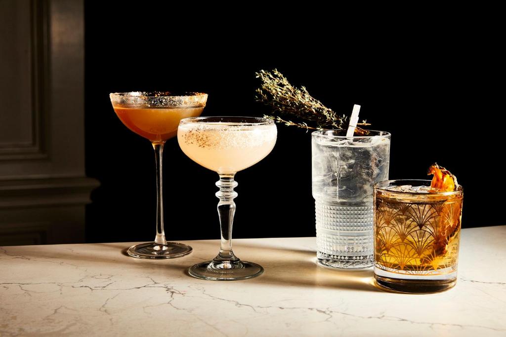 três cocktails sentados numa mesa ao lado do aermottermottermott em Kimpton Shane Atlanta, an IHG Hotel em Atlanta