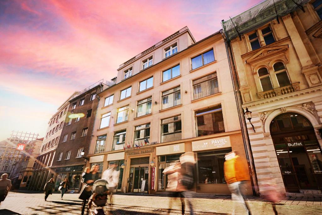 a group of people crossing a street in front of a building at Art Hotel William in Bratislava