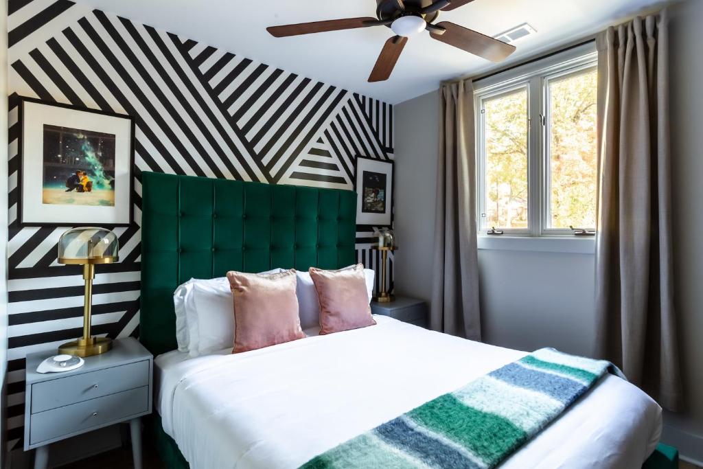 a bedroom with a bed with a green headboard at Kasa Edison House South End Dilworth Charlotte in Charlotte