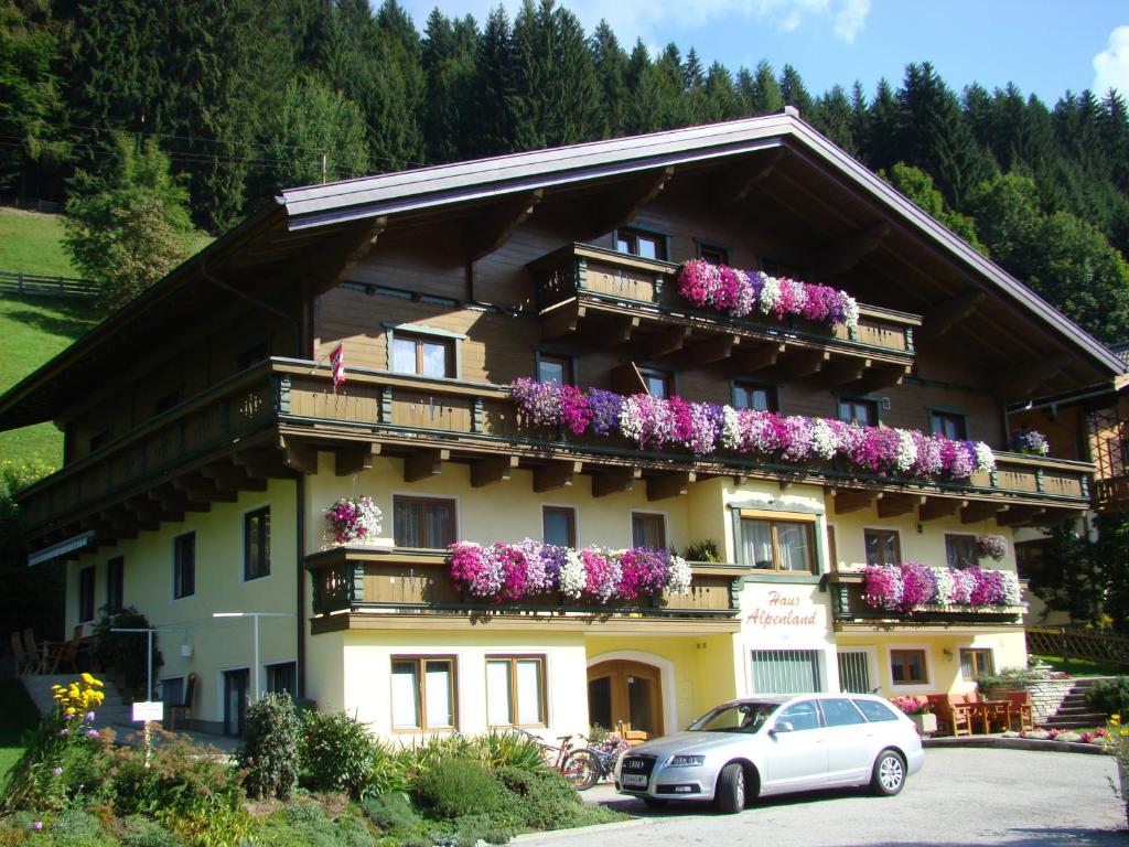 un bâtiment avec des fleurs sur ses balcons dans l'établissement Haus Alpenland, à Wagrain