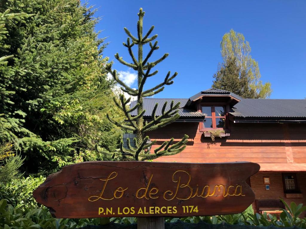 un panneau devant un bâtiment avec un arbre dans l'établissement DAT "Lo de Bianca", à San Carlos de Bariloche