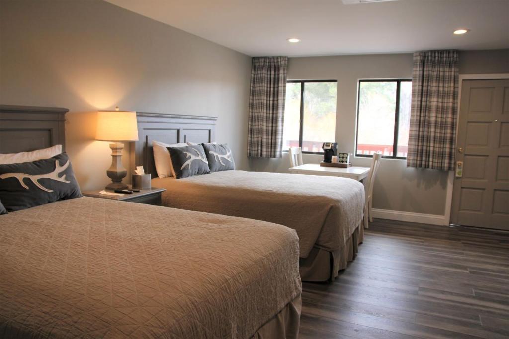 Cette chambre comprend 2 lits et une fenêtre. dans l'établissement Big Bear Frontier, à Big Bear Lake