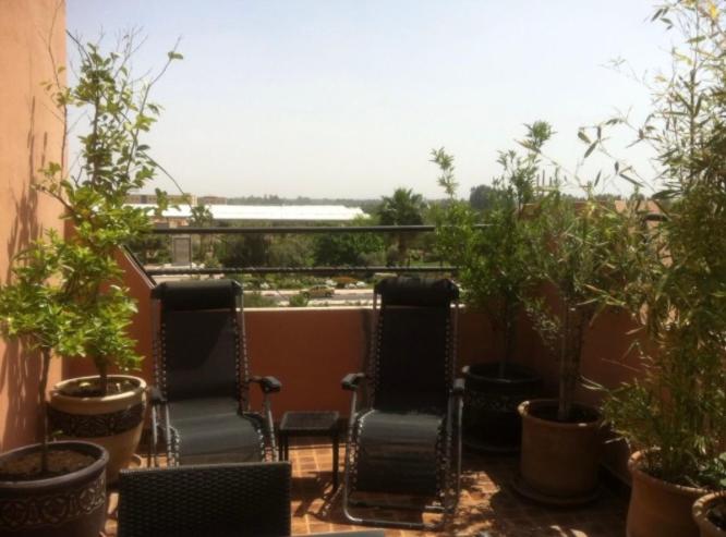 balcón con 2 sillas y macetas en JHDARINNA, en Marrakech