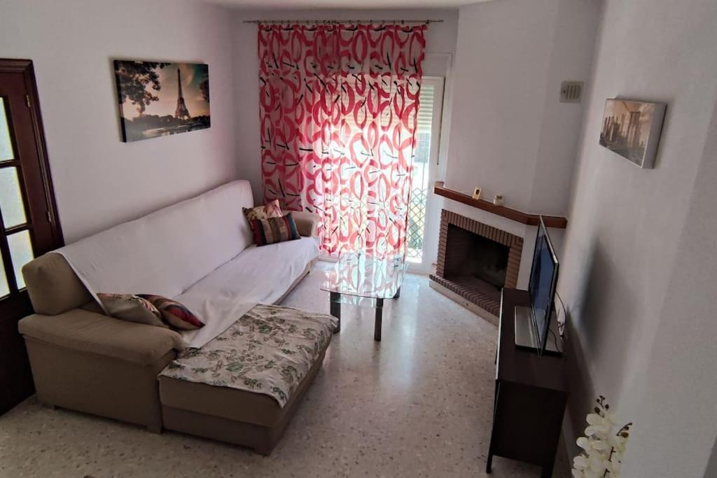 salon z kanapą i kominkiem w obiekcie Casa Gazules w mieście Alcalá de los Gazules