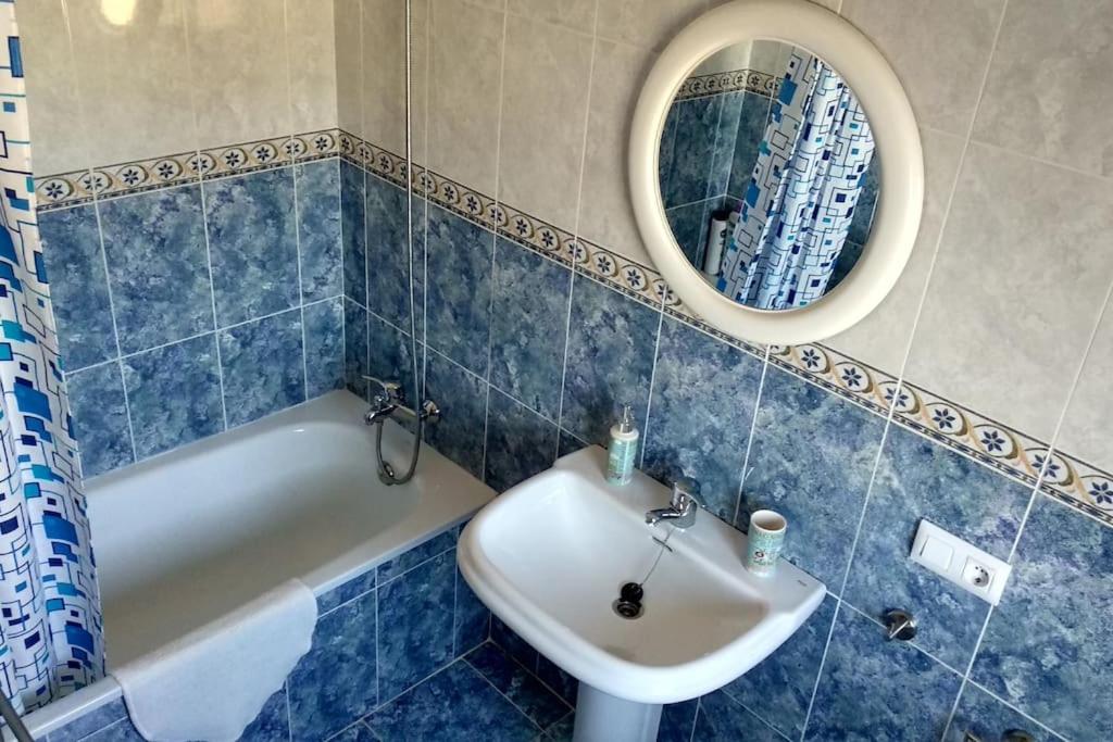 W łazience znajduje się umywalka, wanna i lustro. w obiekcie Casa Gazules w mieście Alcalá de los Gazules
