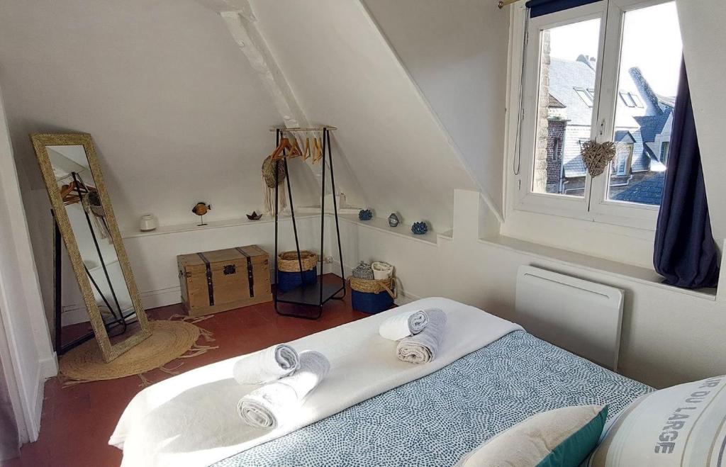 een slaapkamer met een bed en een raam met handdoeken bij La petite Dieppoise 3 étoiles meublé de tourisme Entre plage et port in Dieppe