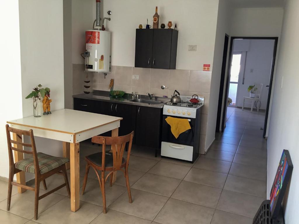 uma cozinha com uma mesa, 2 cadeiras e um fogão em Casa México em Paraná