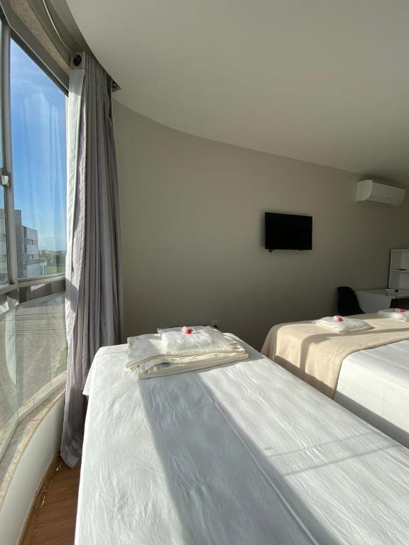 2 camas en una habitación con ventana en Pousada Ritec, en Linhares