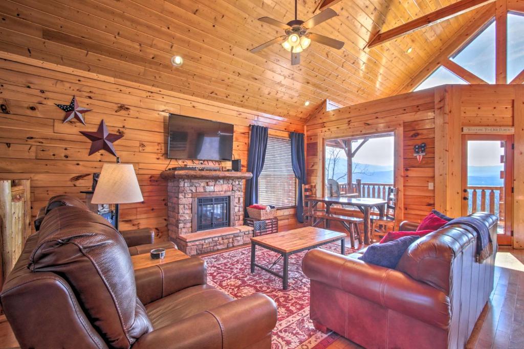un soggiorno con mobili in pelle e camino di Pigeon Forge Mountain Cabin Hot Tub and Resort Pool a Sevierville