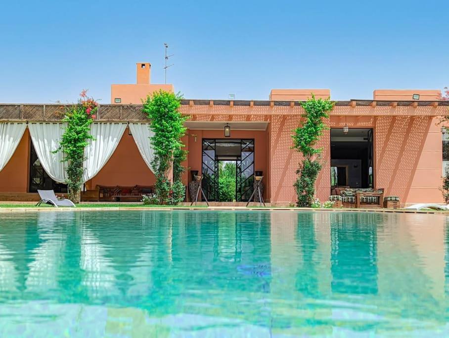 a large swimming pool in front of a building at Villa de luxe service compris in Marrakesh