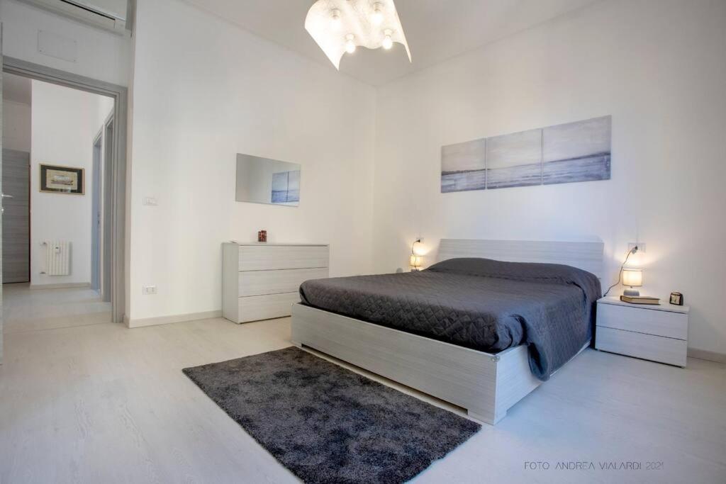 a white bedroom with a bed and a rug at La reggia del mar - Genova Sturla, mare e Gaslini in Genova