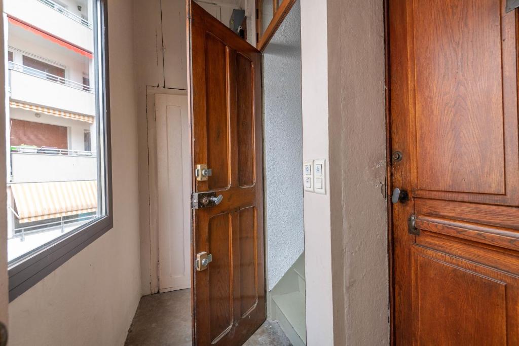 an open wooden door in a room with a window at Pleasant apartment three minutes from the center of Annecy in Annecy