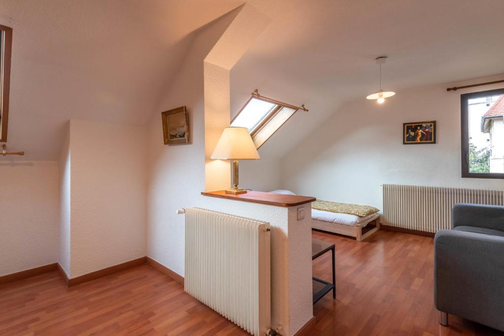 a living room with a bed and a lamp on a table at Pleasant apartment three minutes from the center of Annecy in Annecy