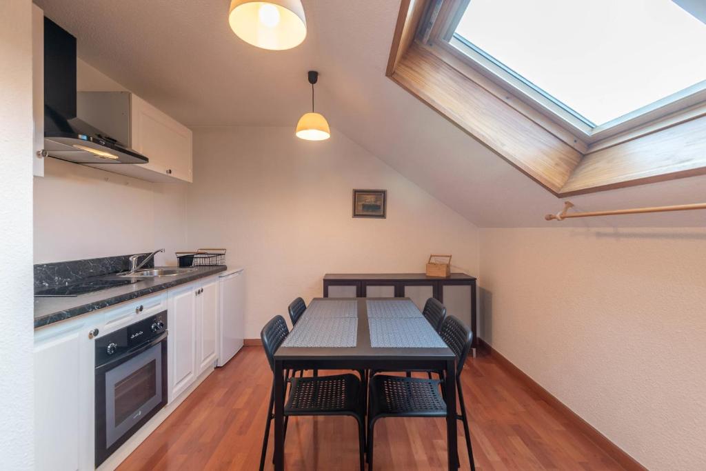 a kitchen with a table and chairs and a window at Pleasant apartment three minutes from the center of Annecy in Annecy