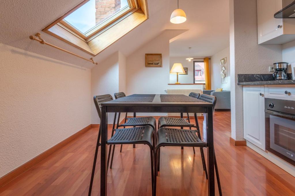 a kitchen with a table and chairs and a skylight at Pleasant apartment three minutes from the center of Annecy in Annecy