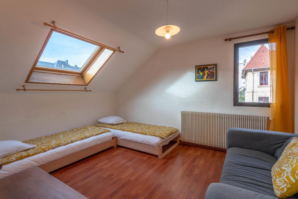a room with two beds and a couch and a window at Pleasant apartment three minutes from the center of Annecy in Annecy
