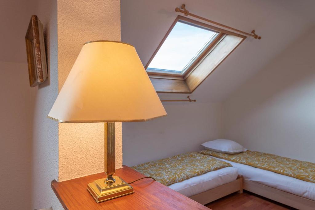 a lamp on a table in a bedroom with a window at Pleasant apartment three minutes from the center of Annecy in Annecy