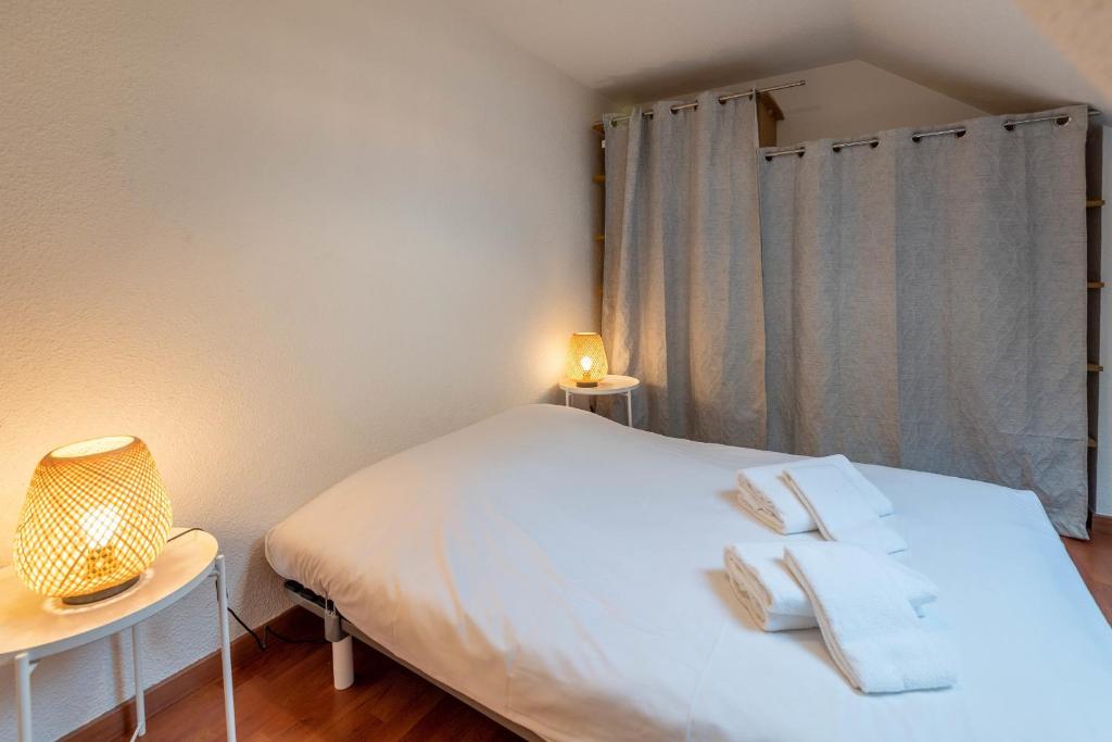 a bedroom with a white bed with two towels on it at Pleasant apartment three minutes from the center of Annecy in Annecy